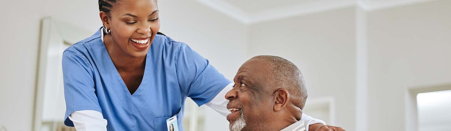 Nurse helps older man with cane